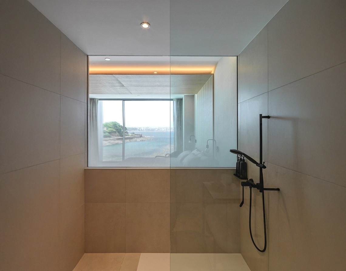a bathroom with a walk in shower and a view of the ocean