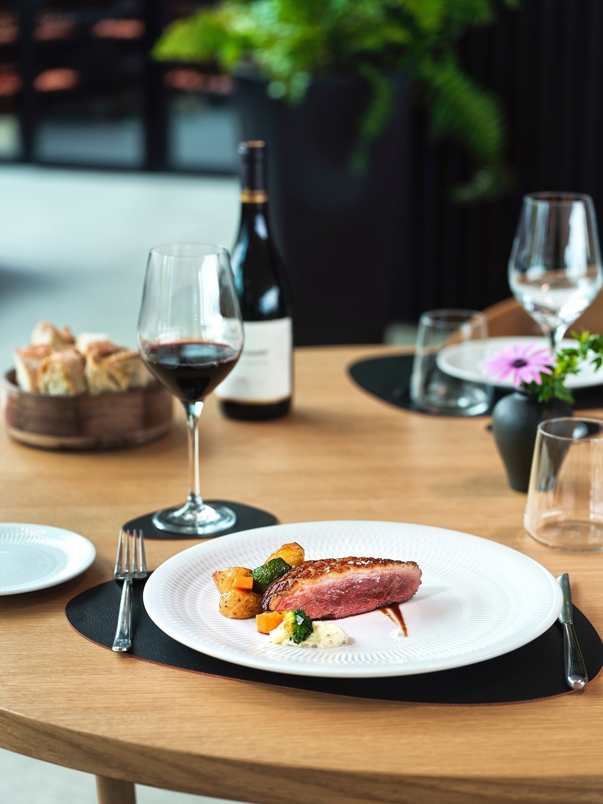 una mesa con un plato de comida y una botella de vino