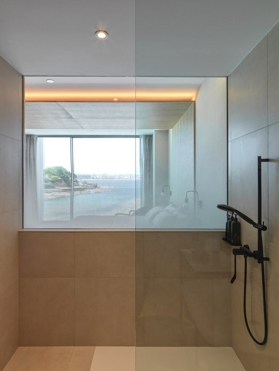 a bathroom with a walk in shower and a view of the ocean