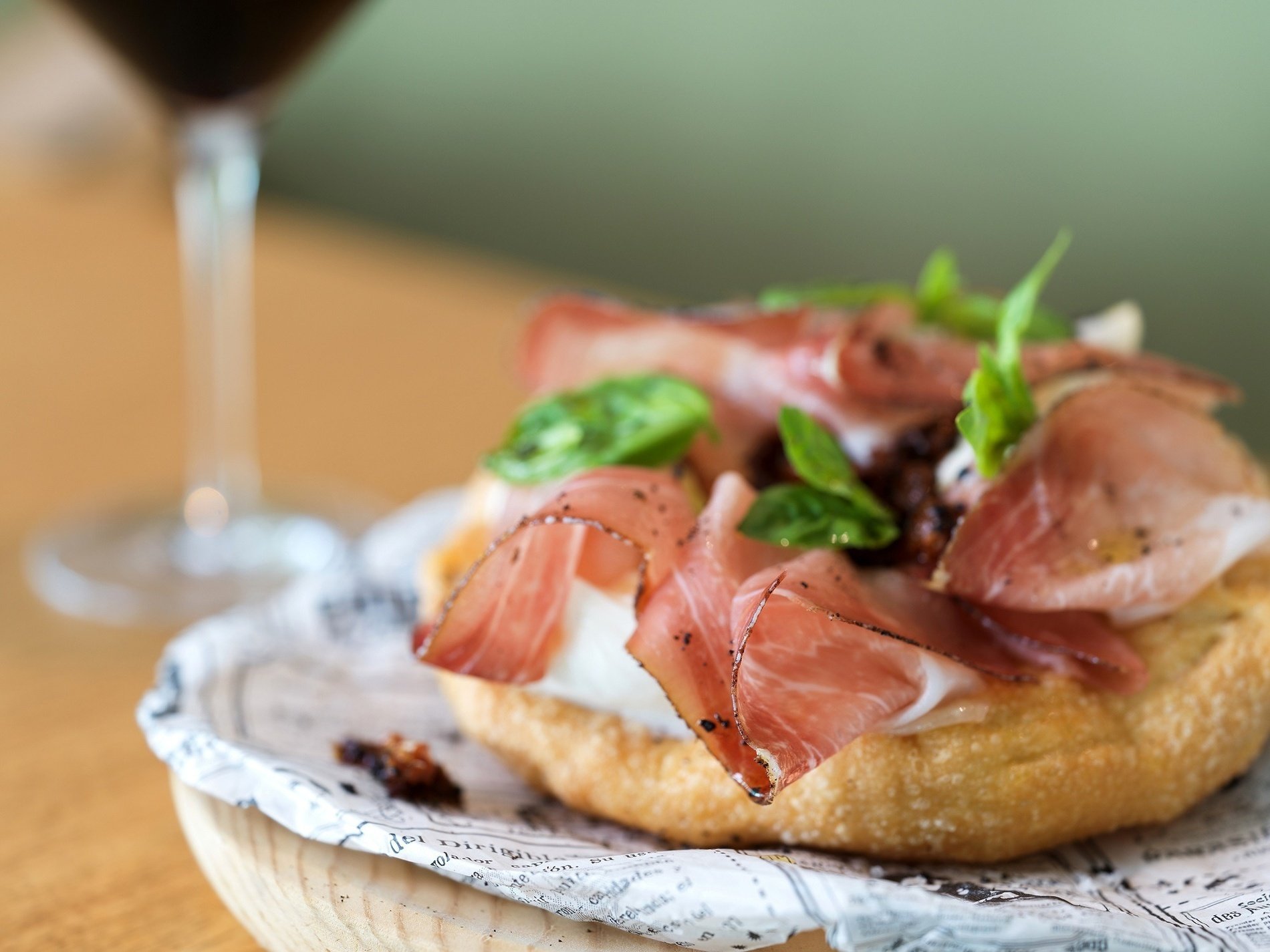 un primer plano de un plato de comida con un vaso de vino en el fondo