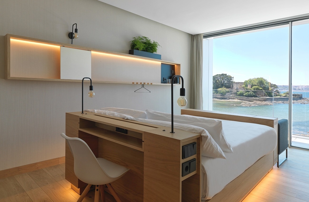 una habitación con una cama y una ventana con vista al océano