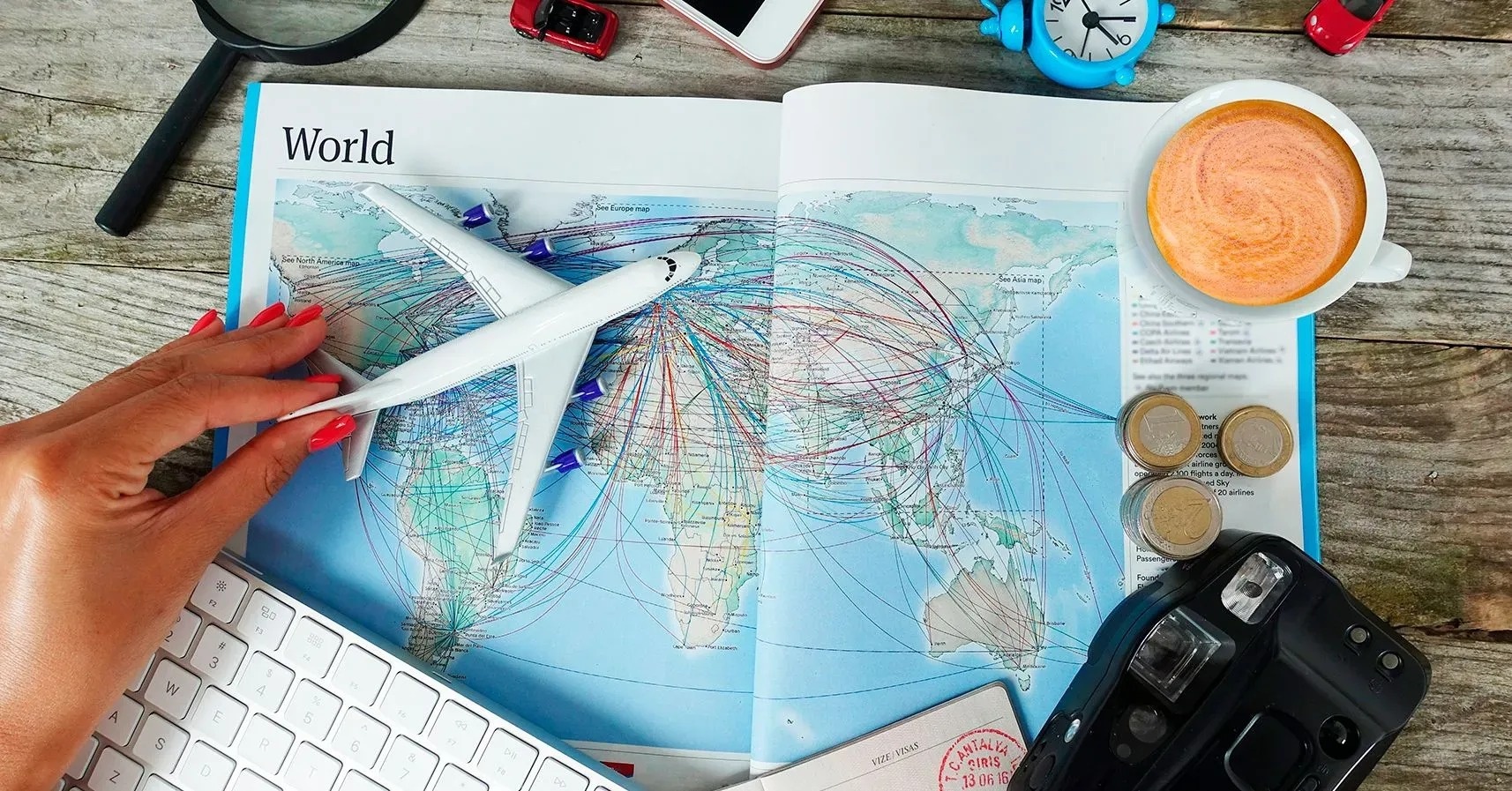 una persona sostiene un modelo de avión encima de un mapa del mundo