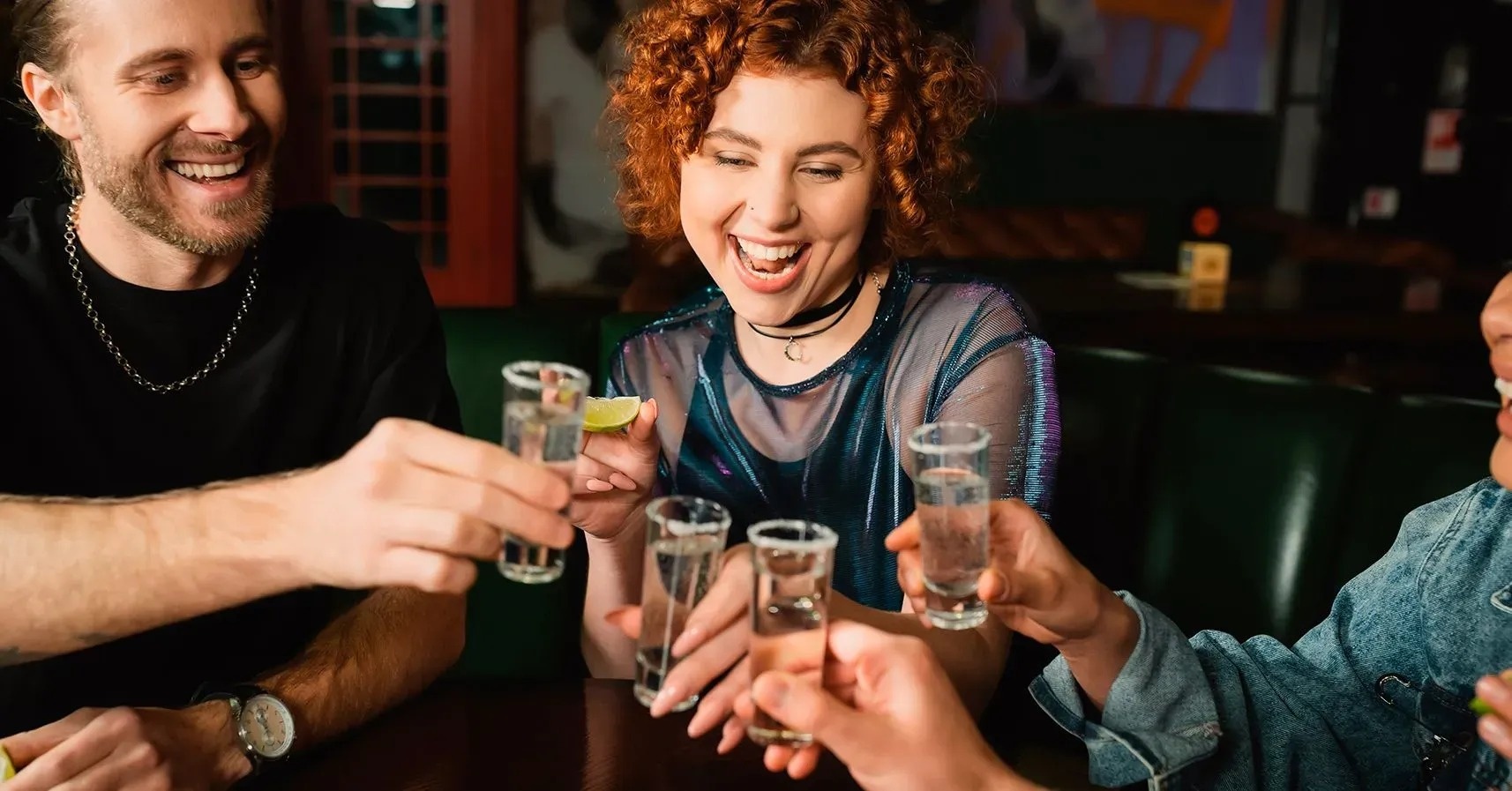 un grupo de personas tomando tequila en un bar