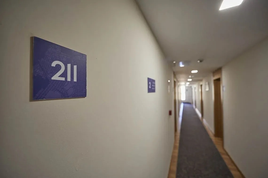 un pasillo con una señal que dice 211 en la pared