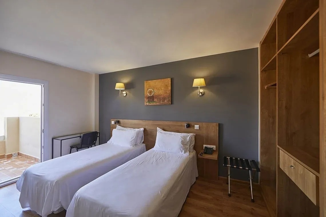 una habitación con dos camas y una pintura en la pared
