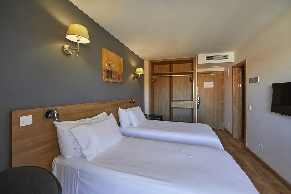 una habitación de hotel con dos camas y una televisión