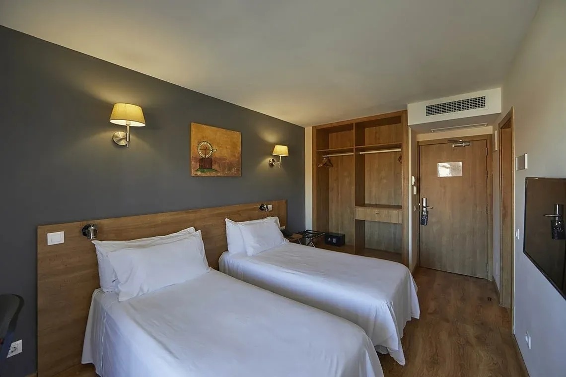 una habitación de hotel con dos camas y una televisión