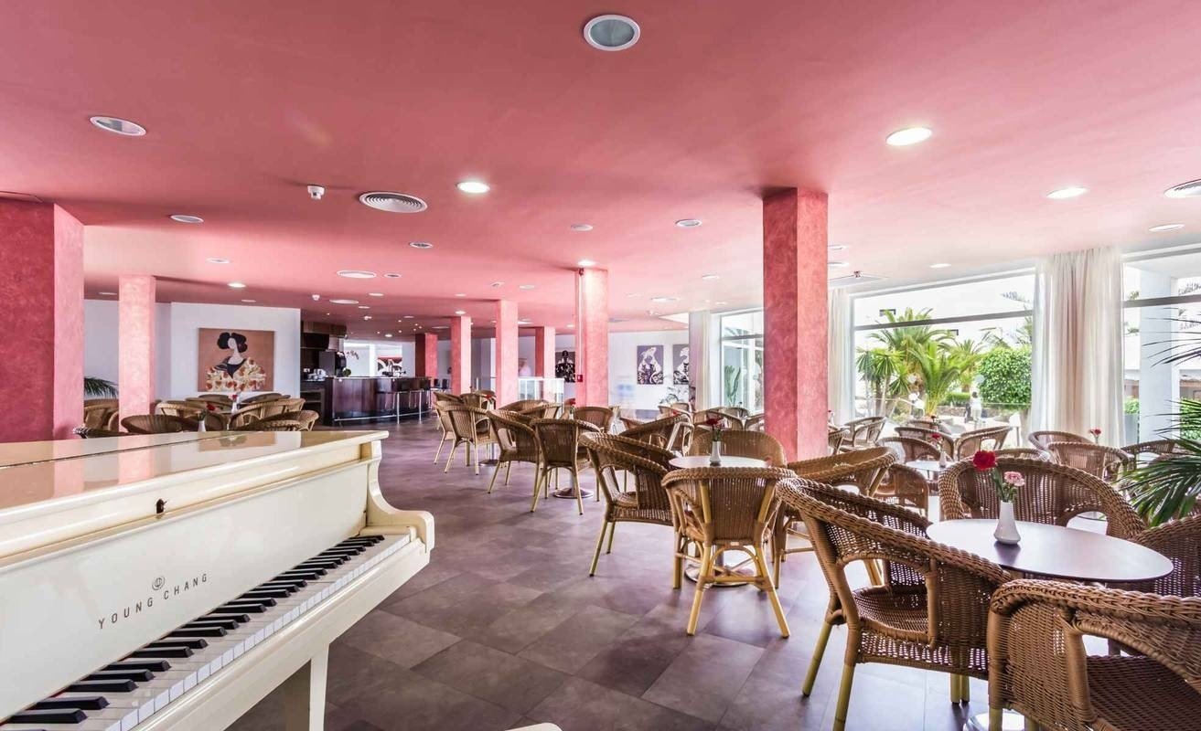 un pianoforte bianco in un ristorante con un soffitto rosa