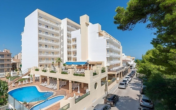 un grand bâtiment blanc avec une piscine devant