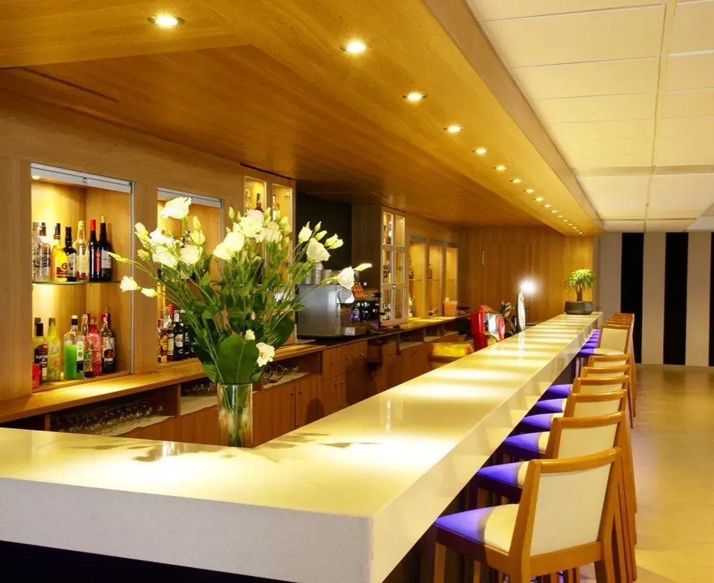 una grande piscina circondata da sedie e un bar