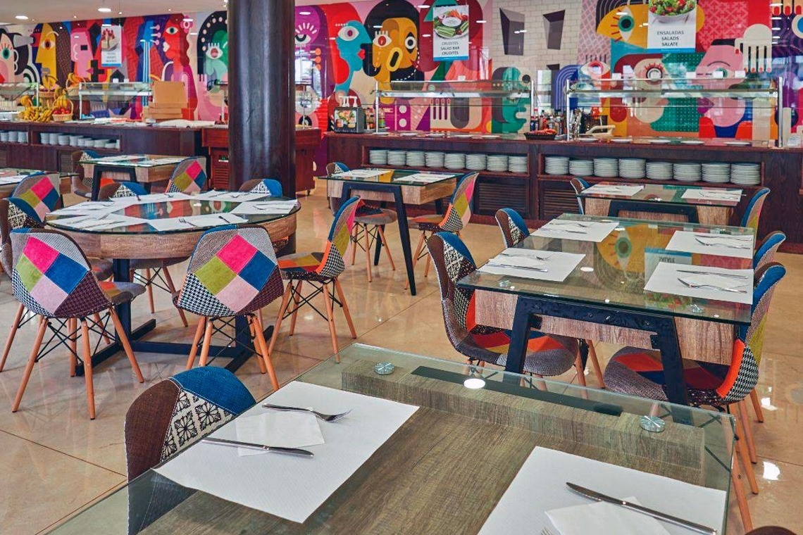 a glass of red liquid with a straw on the beach