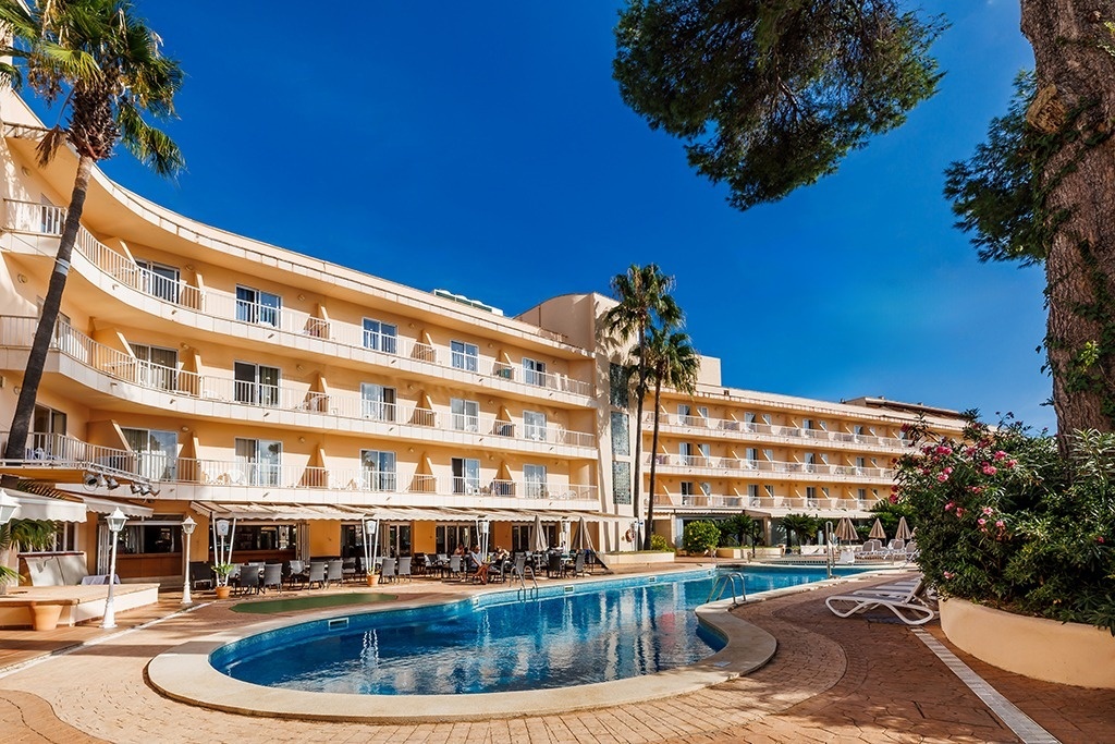Beach with umbrellas, seats and palm trees of the Hotel Park Royal Beach Acapulco