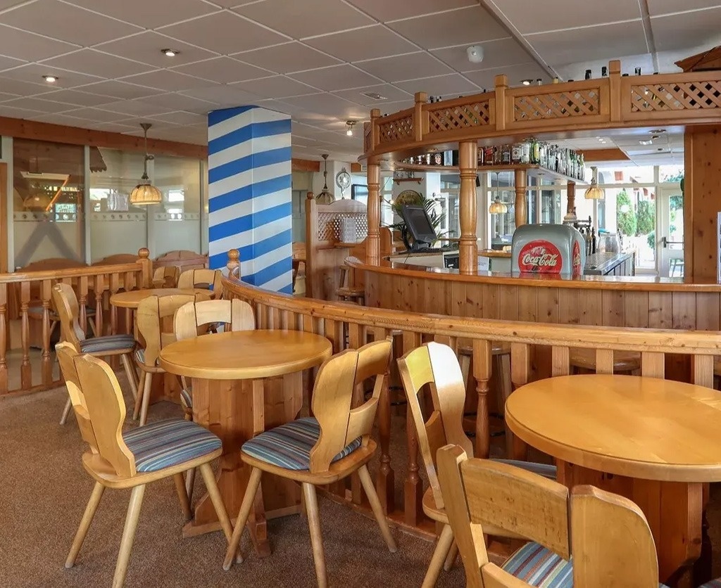 una grande piscina circondata da sedie e un bar