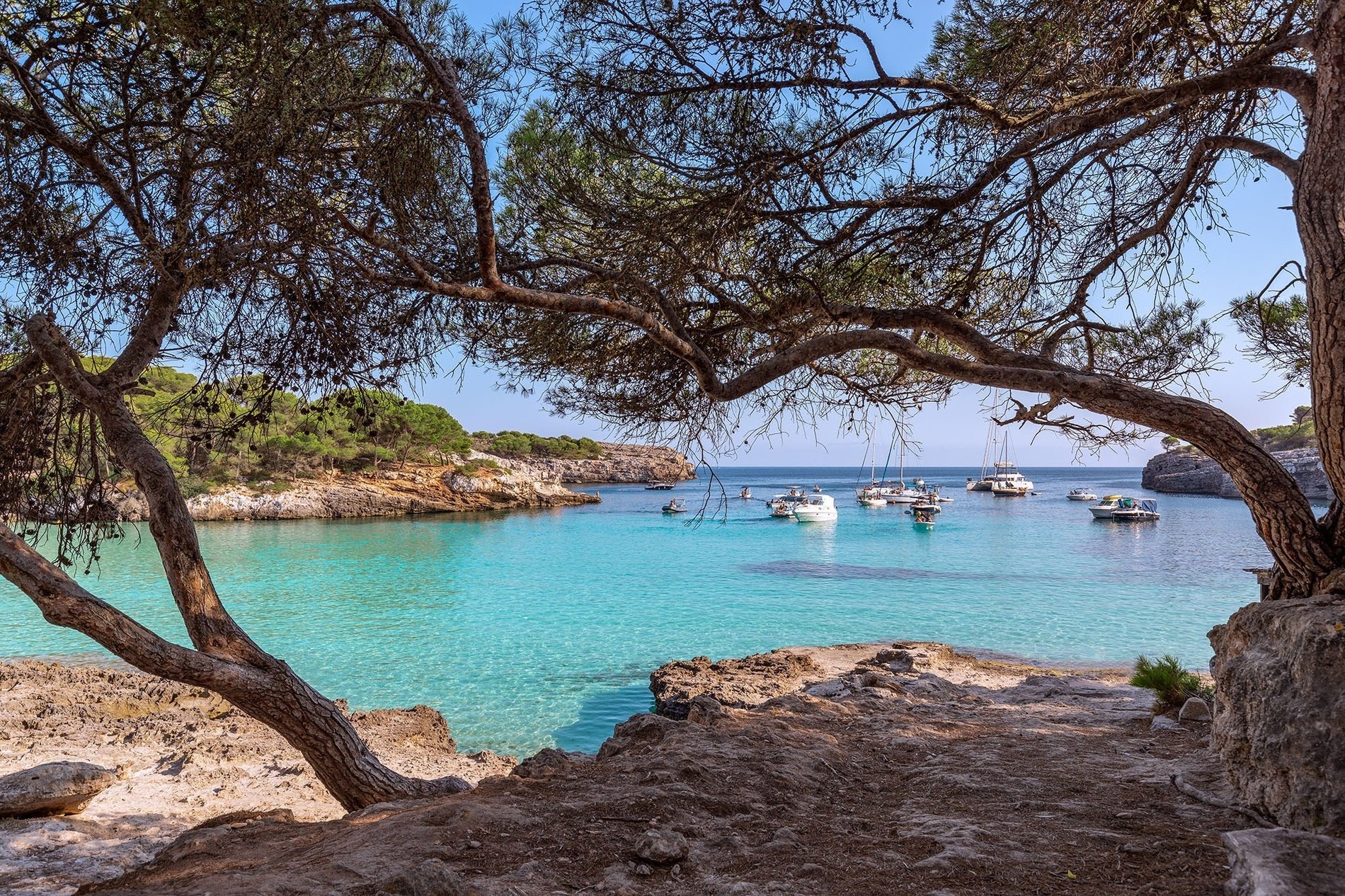 a sandy beach with a rocky cliff in the background