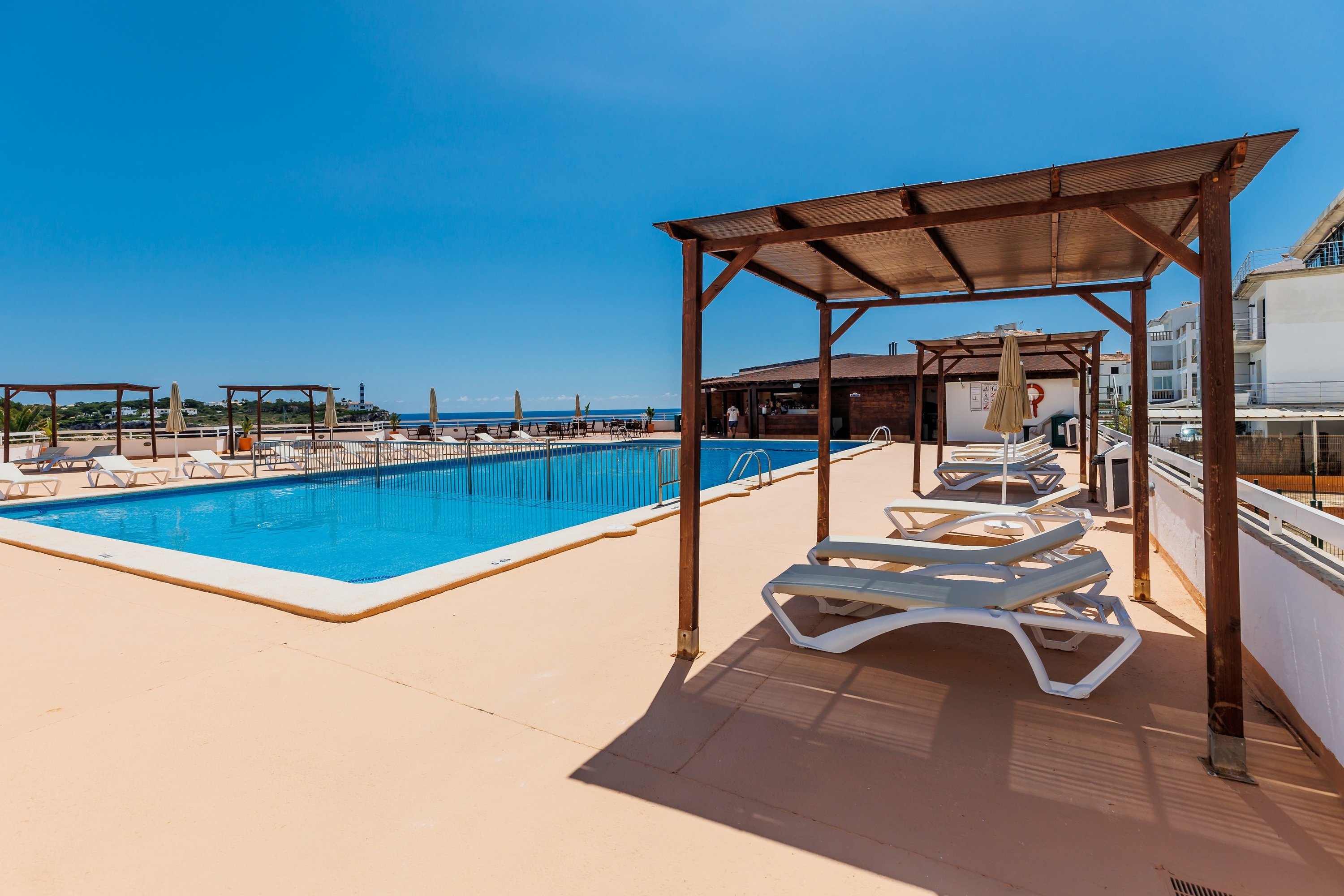 una grande piscina circondata da sedie e un gazebo