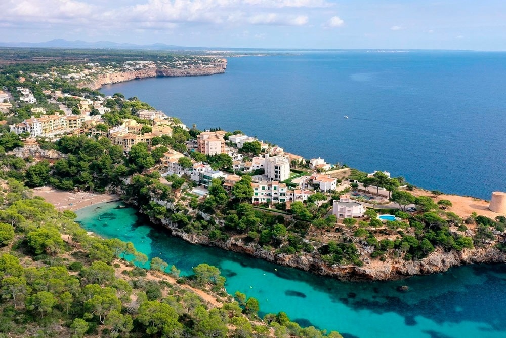 a glass of red liquid with a straw on the beach