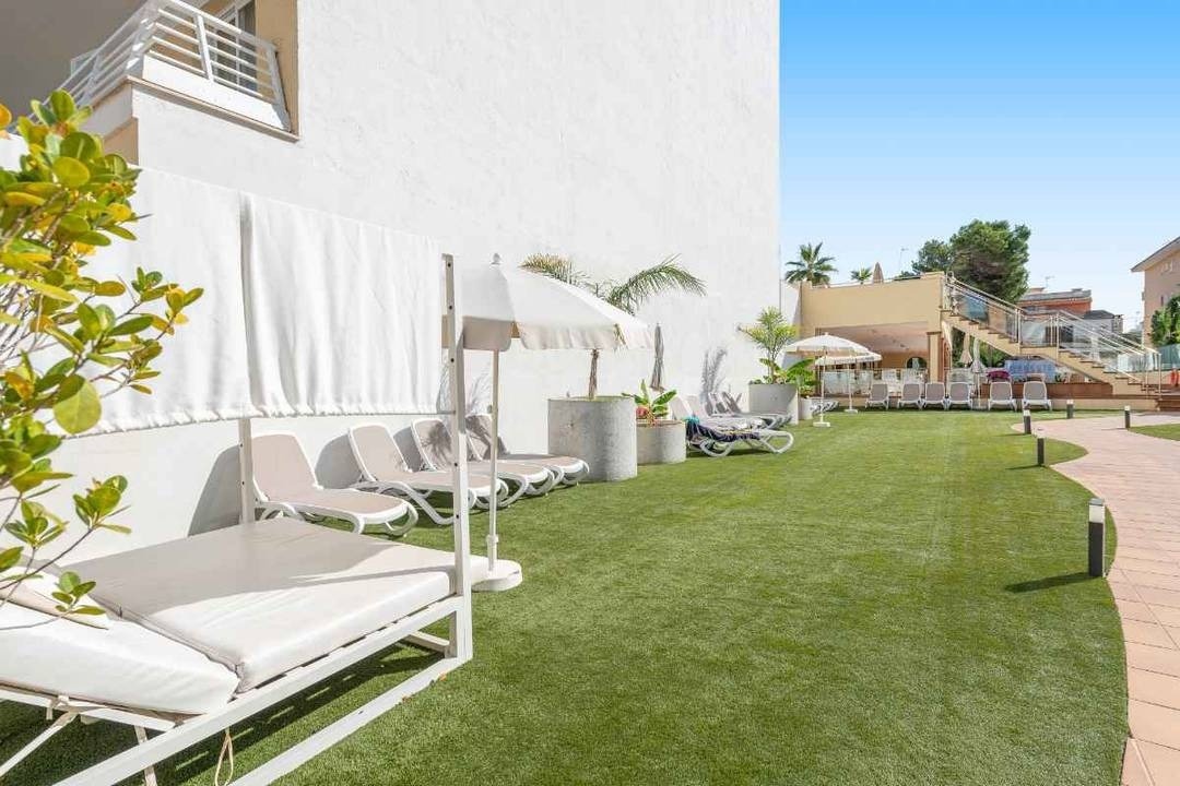 Beach with umbrellas, seats and palm trees of the Hotel Park Royal Beach Acapulco
