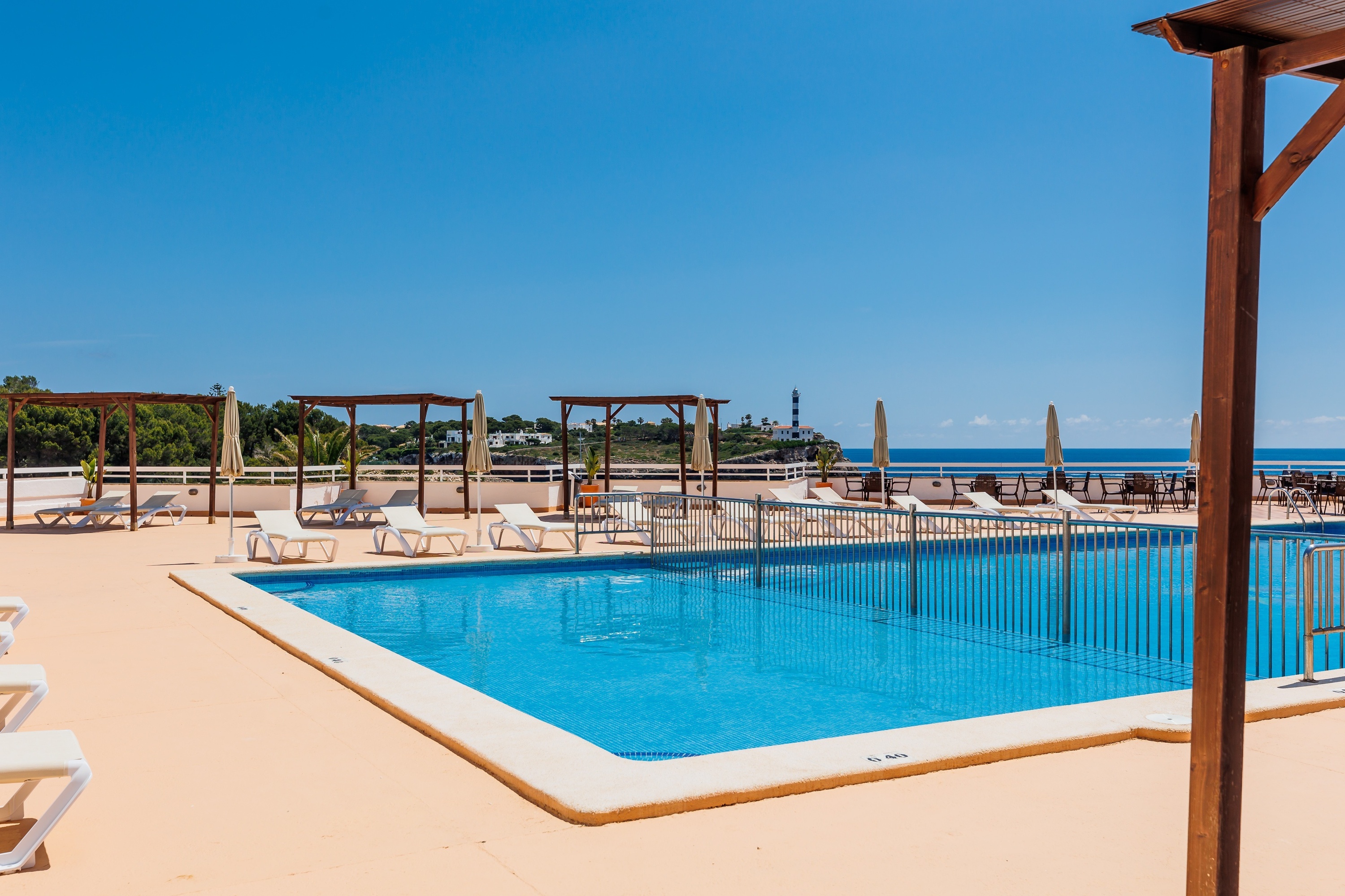 una grande piscina circondata da sedie e ombrelloni