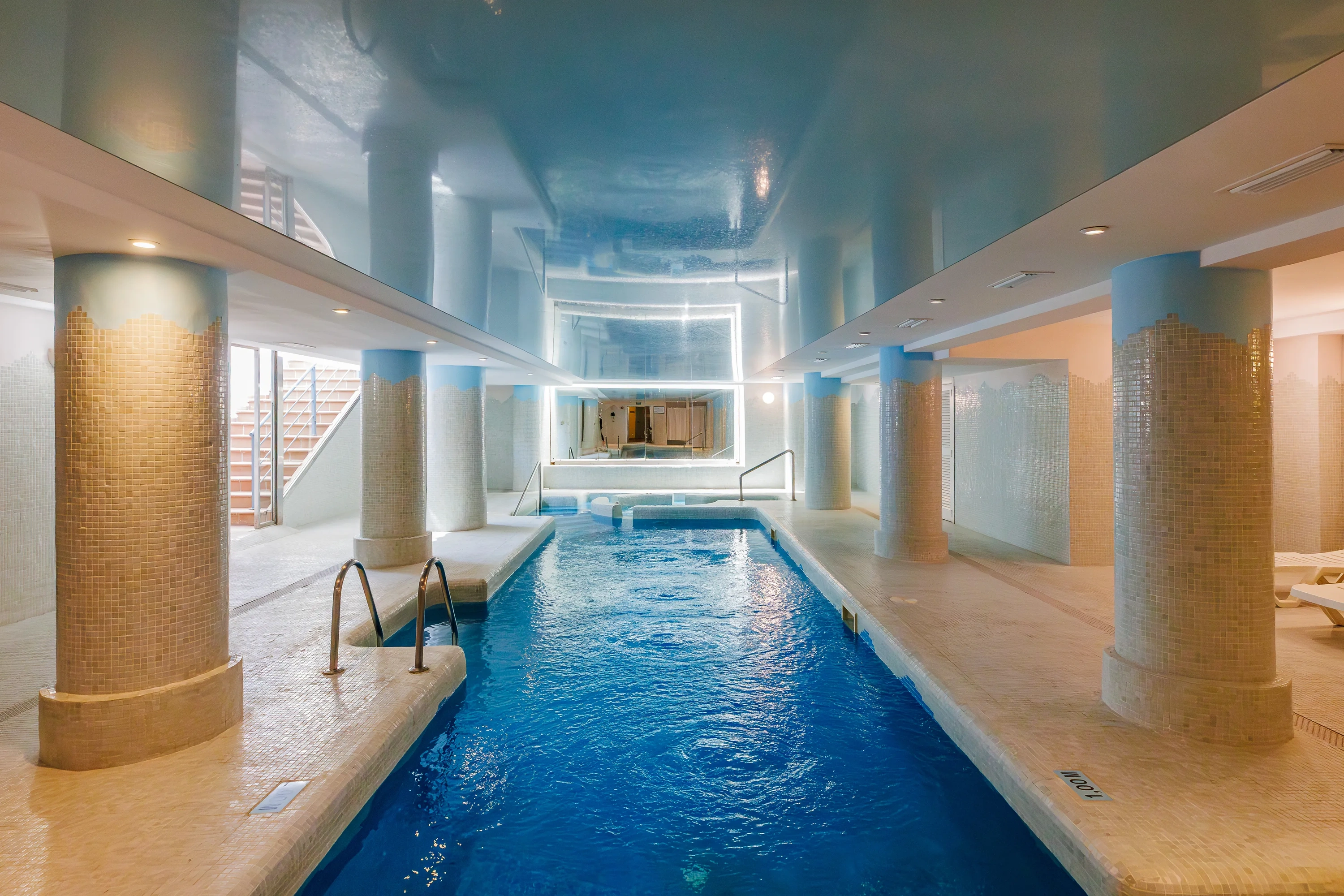 O7 HOTELS: Corporativa indoor pool with columns and tiles.