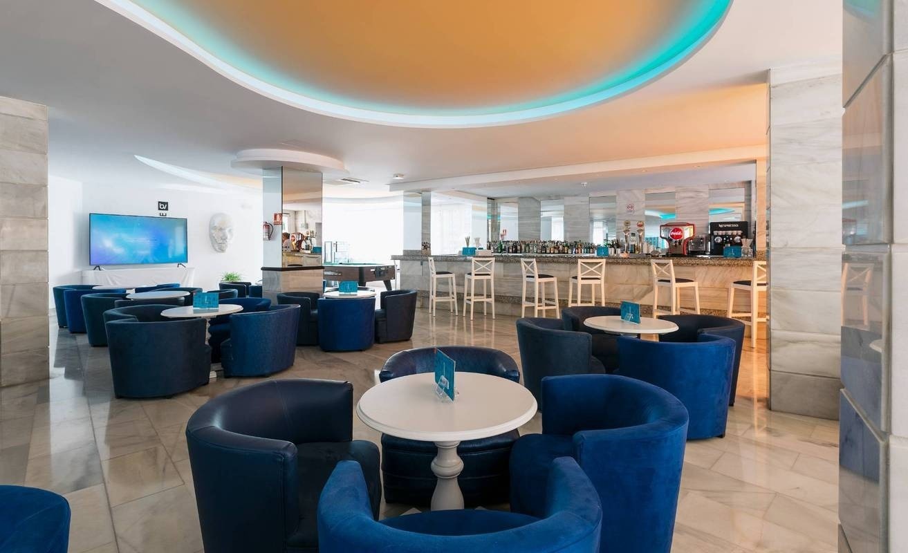 una bebida roja con una pajita en la playa