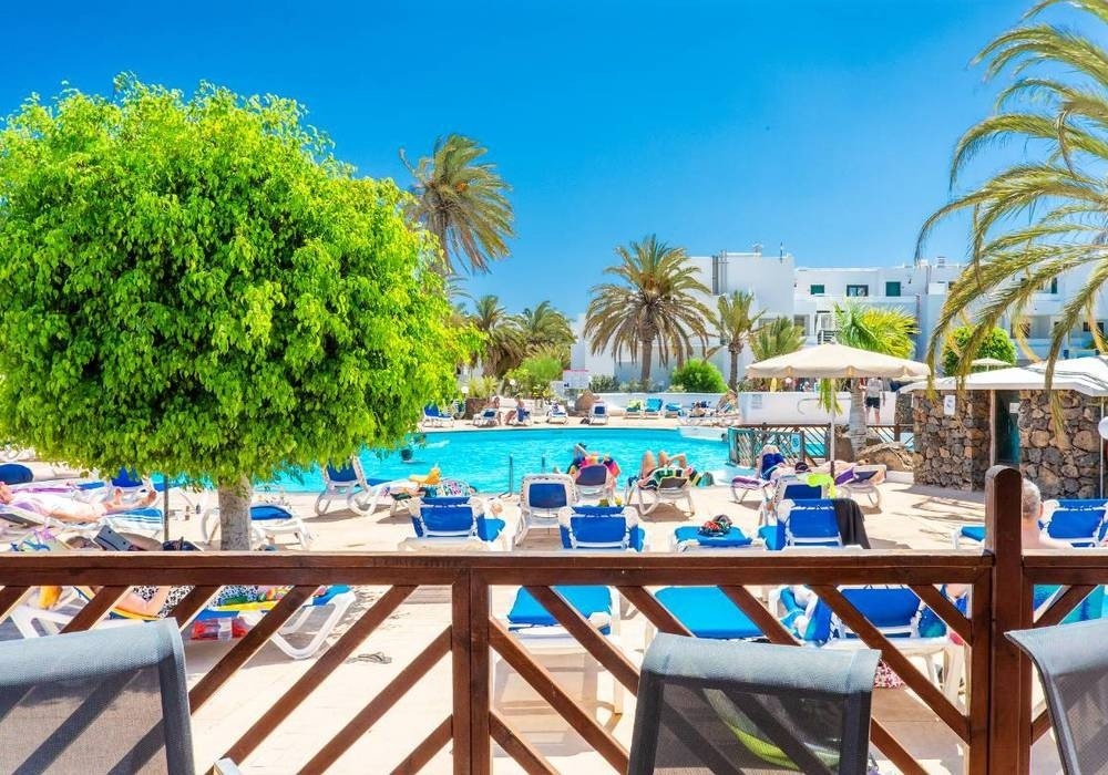 una piscina è circondata da molte sedie e ombrelloni