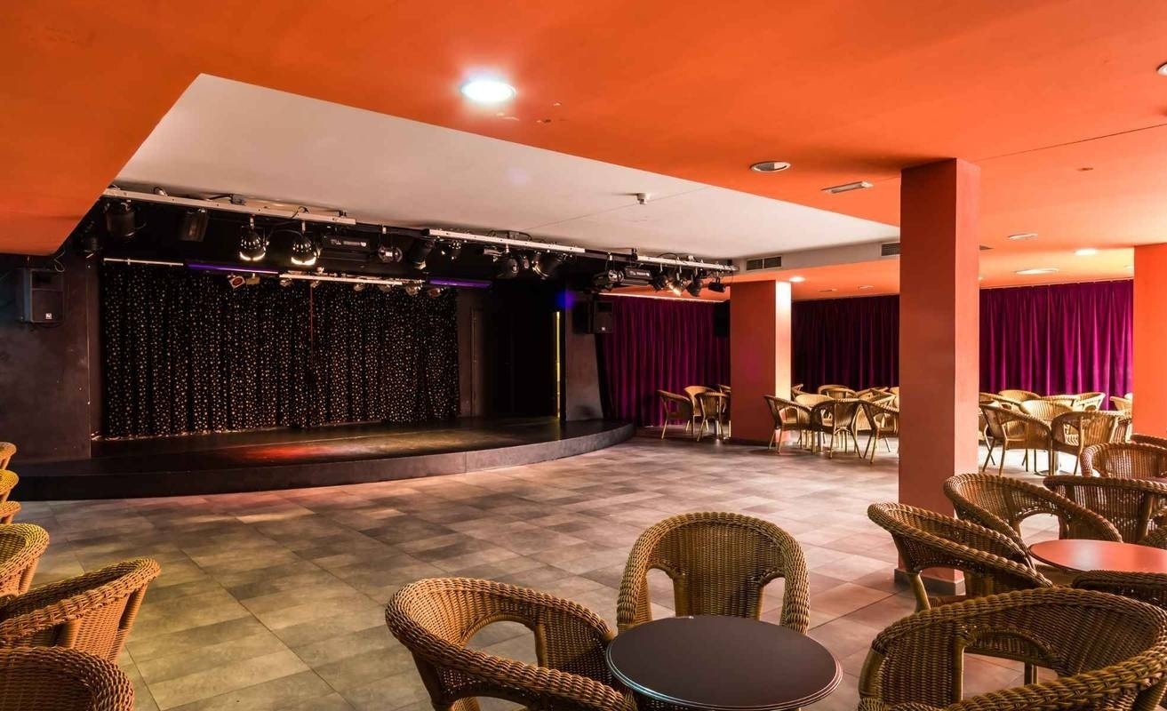 una sala con tavoli e sedie e un palco