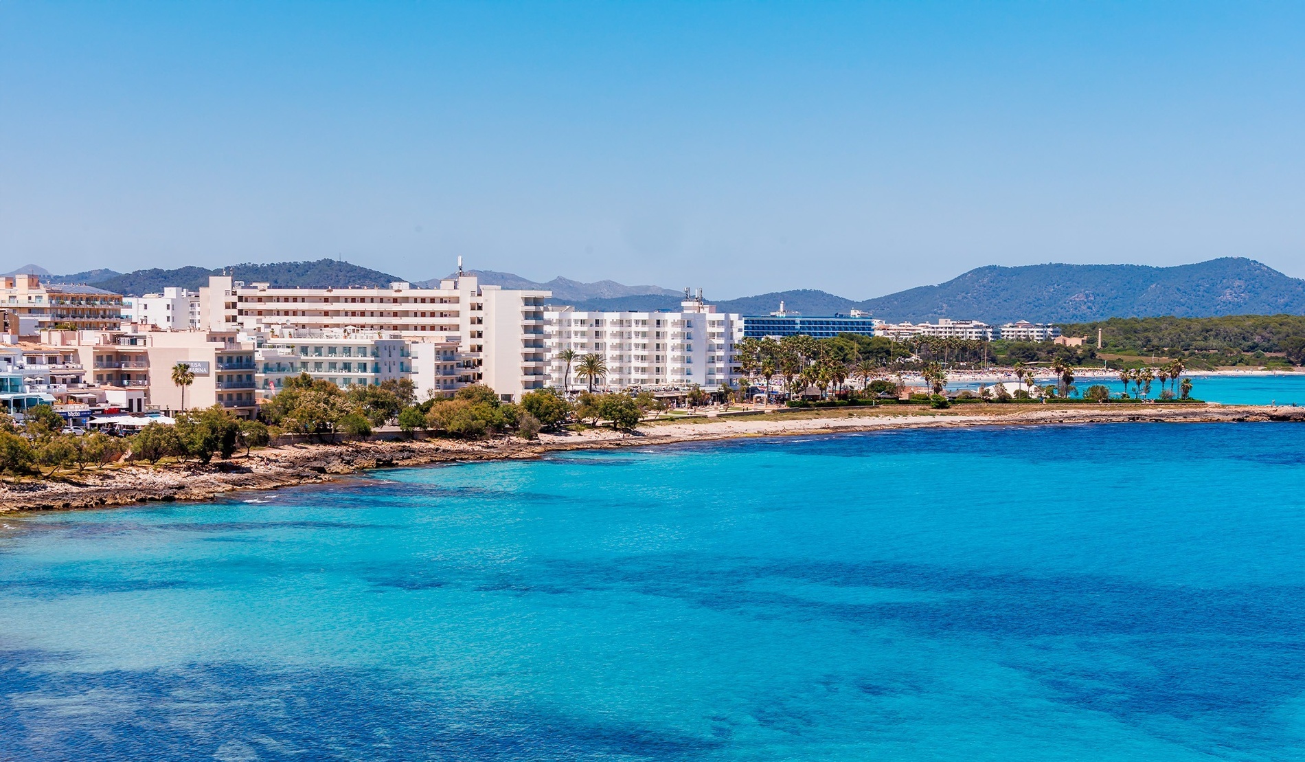 ein Strand mit vielen Gebäuden und einem großen Gebäude im Hintergrund