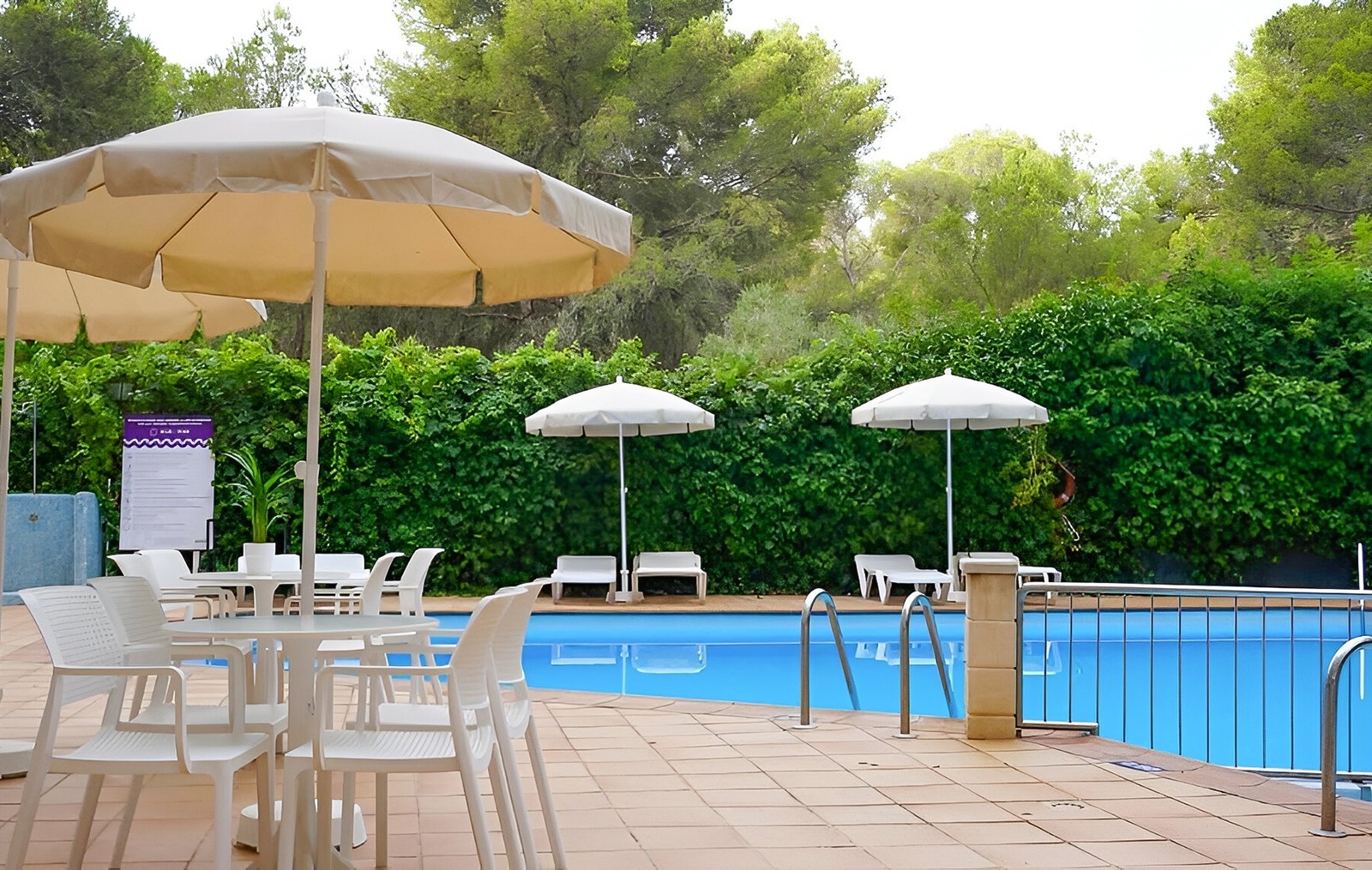 Beach with umbrellas, seats and palm trees of the Hotel Park Royal Beach Acapulco
