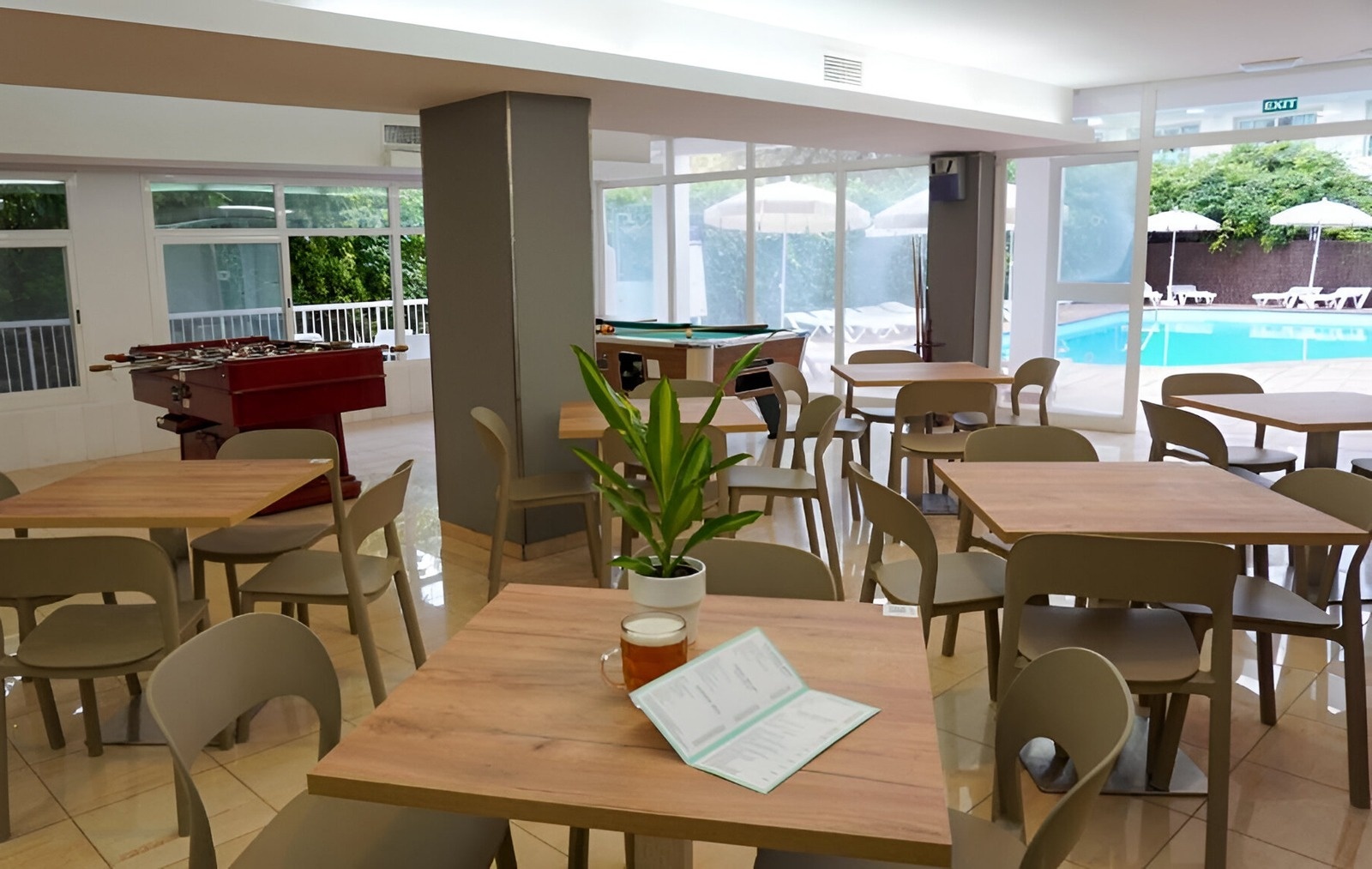 a glass of red liquid with a straw on the beach
