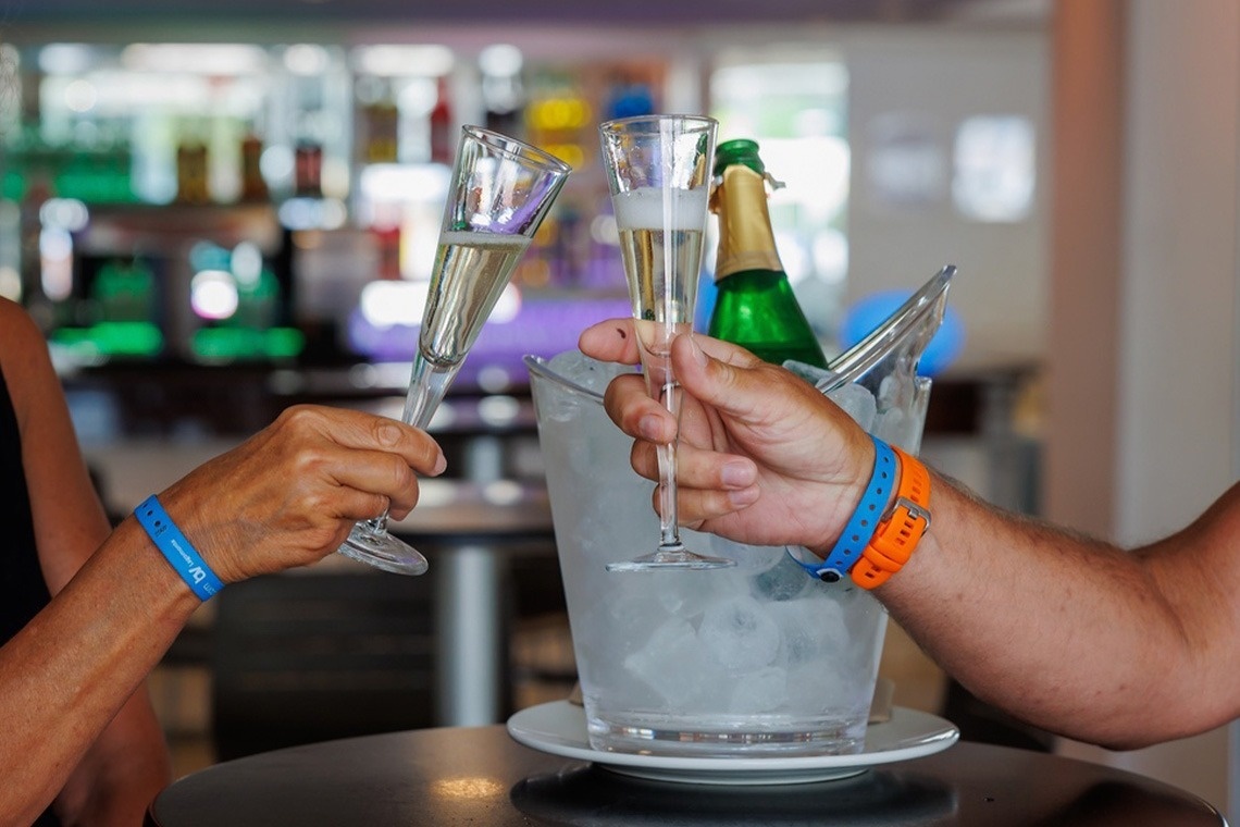 un uomo e una donna brindano con un bicchiere di champagne