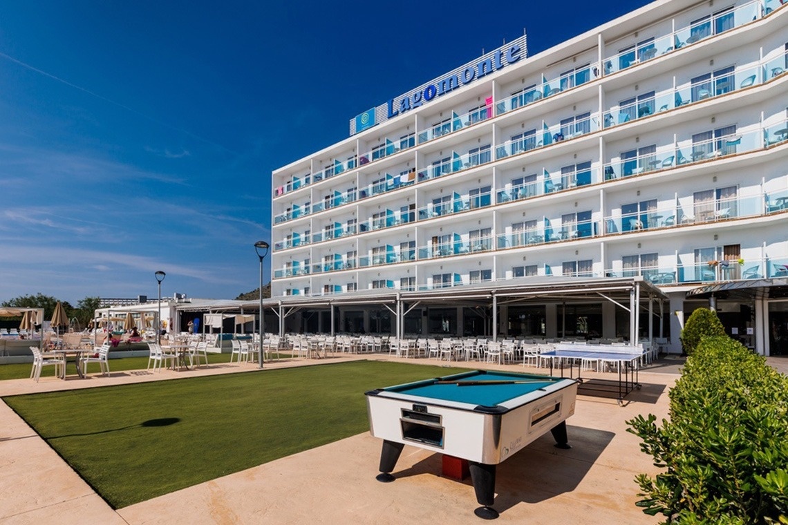 un tavolo da biliardo è in piedi davanti a un grande hotel