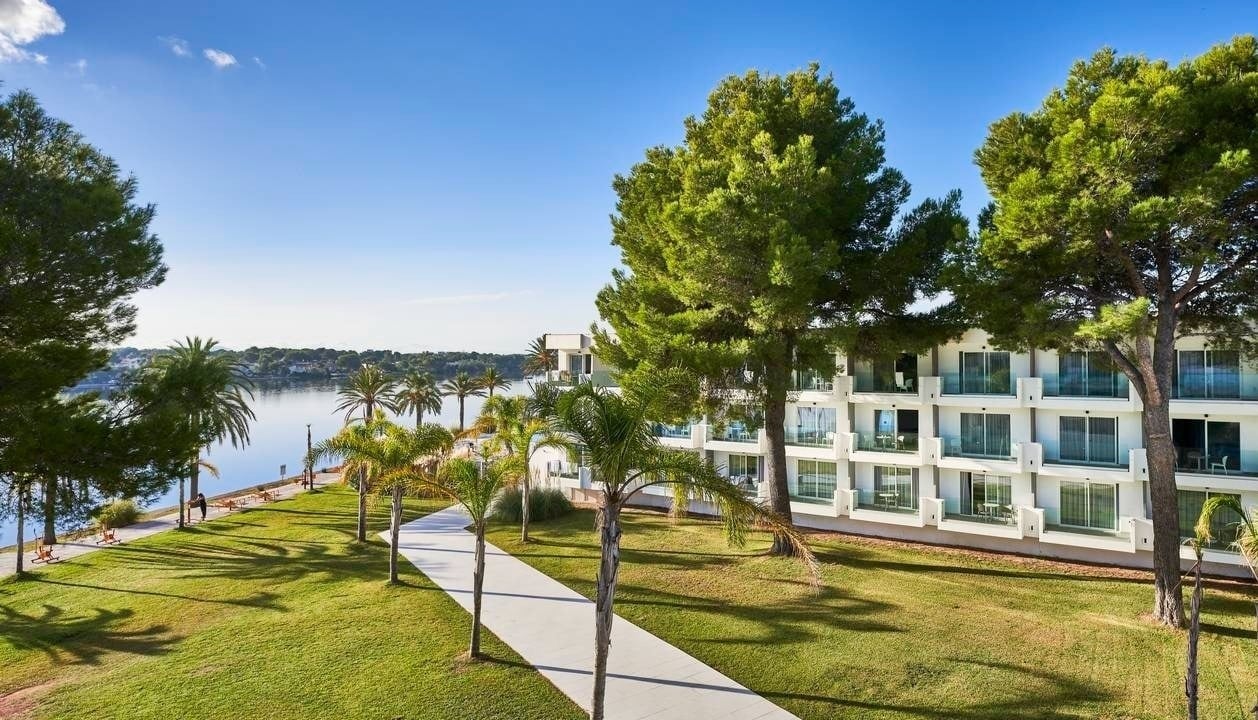 Hotel with sea view, palm trees, and lawn. O7 HOTELS: Corporativa.