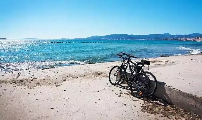 due biciclette sono parcheggiate su una spiaggia vicino all'oceano .