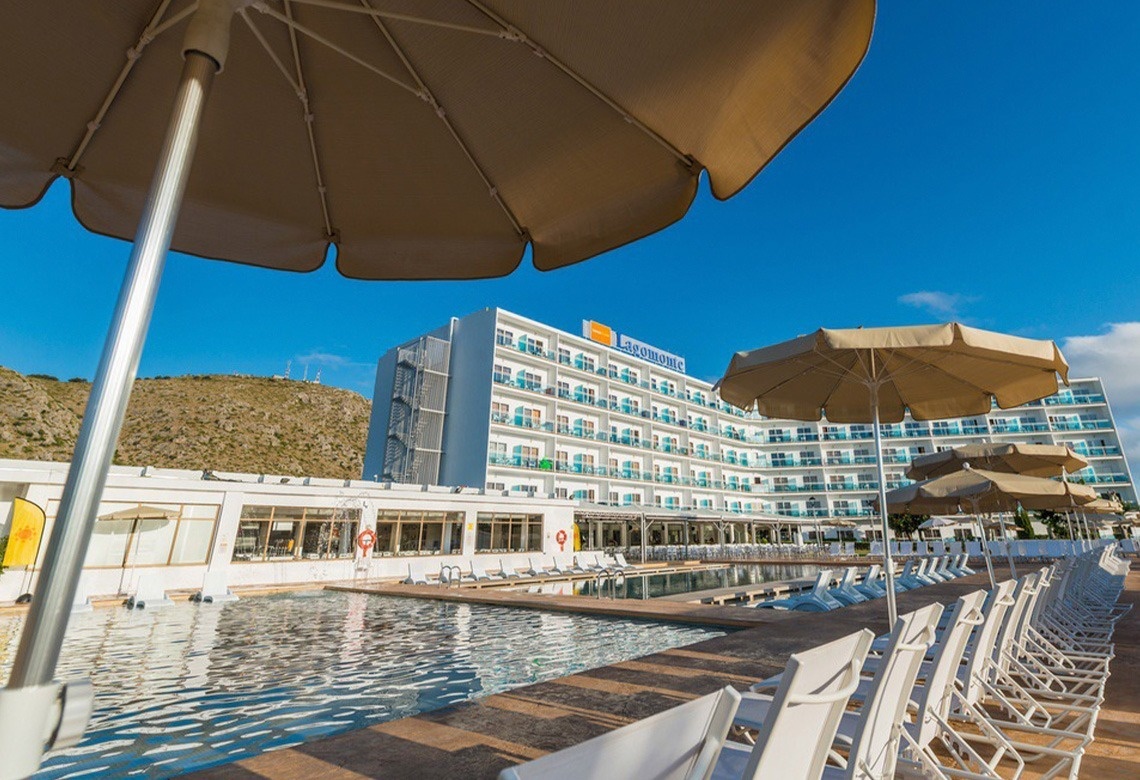 un grande hotel con piscina e molte sedie e ombrelloni