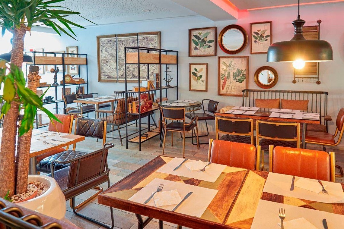 a glass of red liquid with a straw on the beach