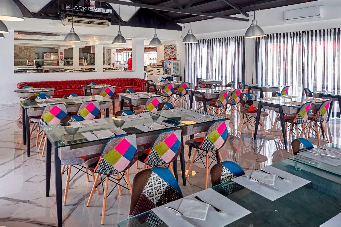 a restaurant with colorful tables and chairs and a sign that says black & white