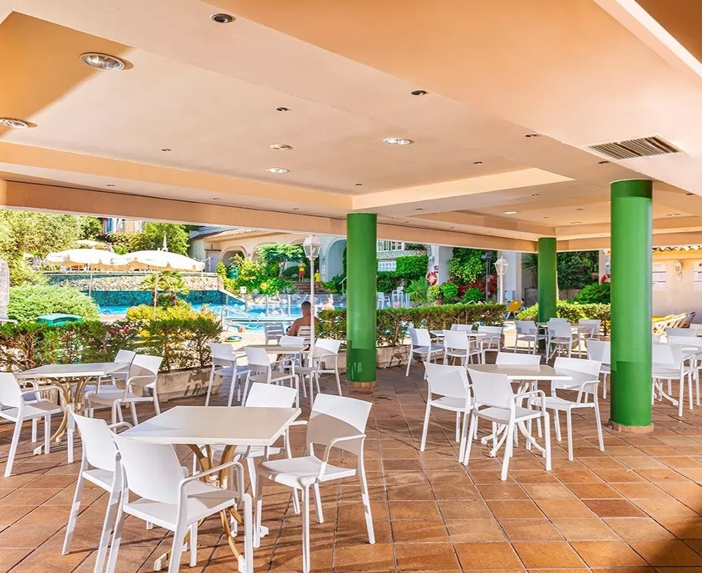 una grande piscina circondata da sedie e un bar