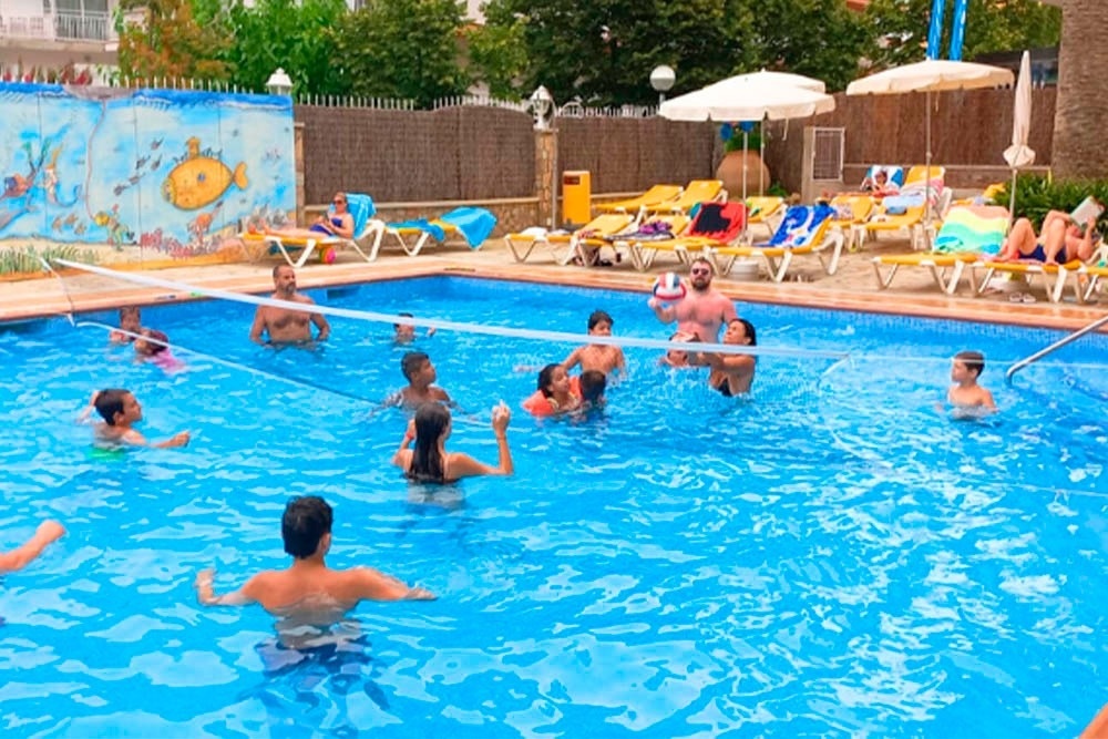 una grande piscina circondata da sedie e un bar