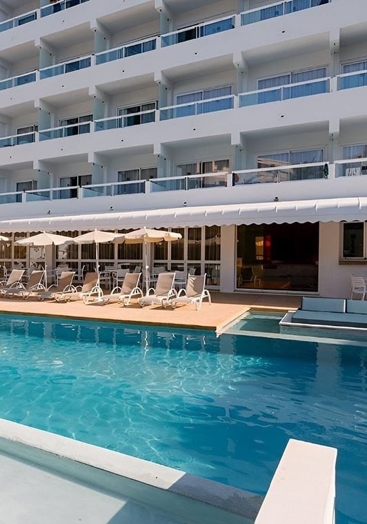 dos mujeres flotan en una piscina y sostienen copas de vino