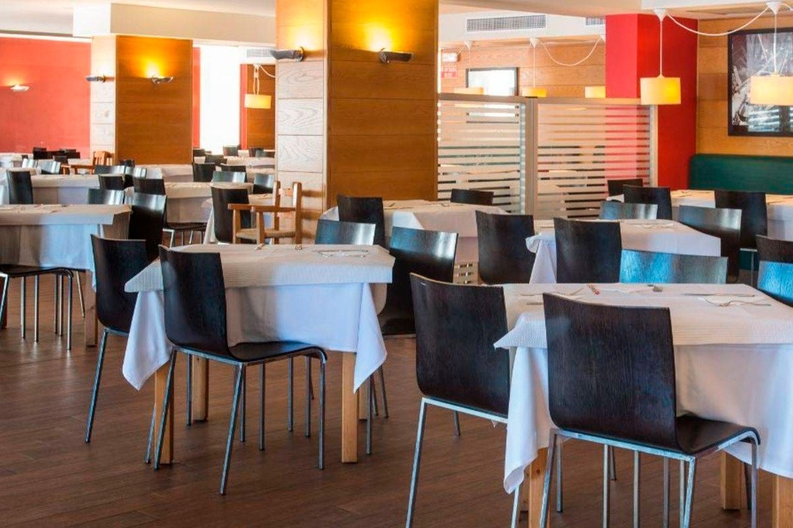 tables and chairs in a restaurant with white tables cloths