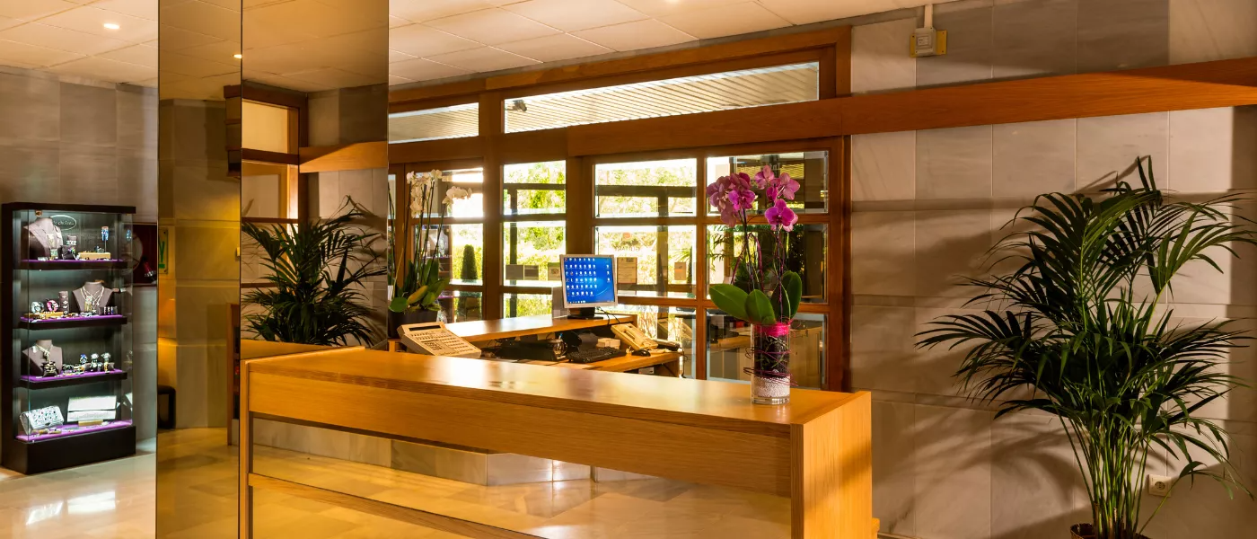 un mostrador de recepción de un hotel con una pantalla de computadora encima