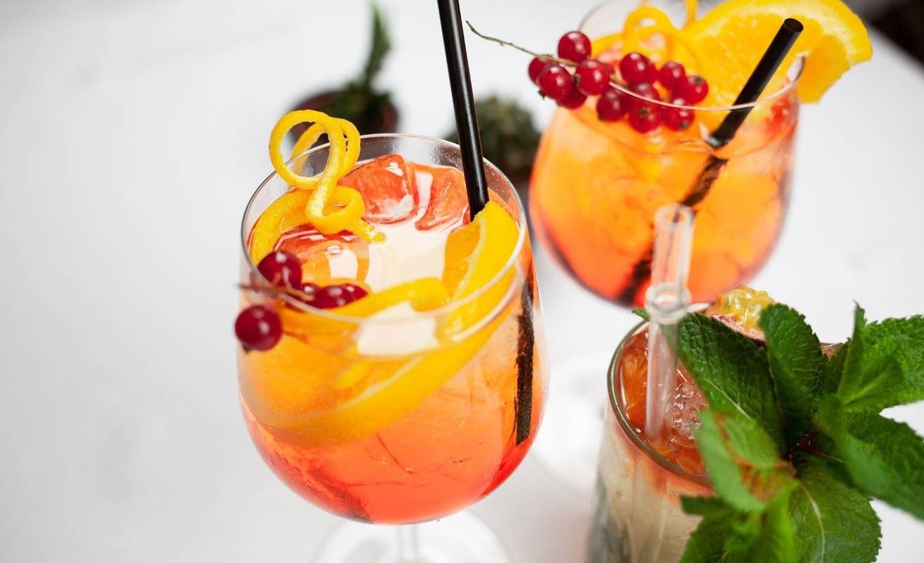 una bebida roja con una pajita en la playa