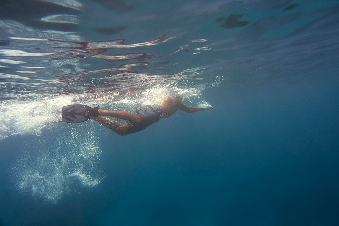 a person is swimming in the ocean with a mask on