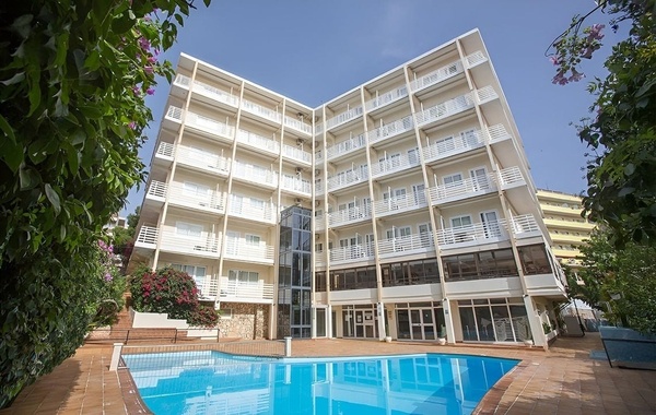 ein großes Hotelgebäude mit einem Pool im Vordergrund