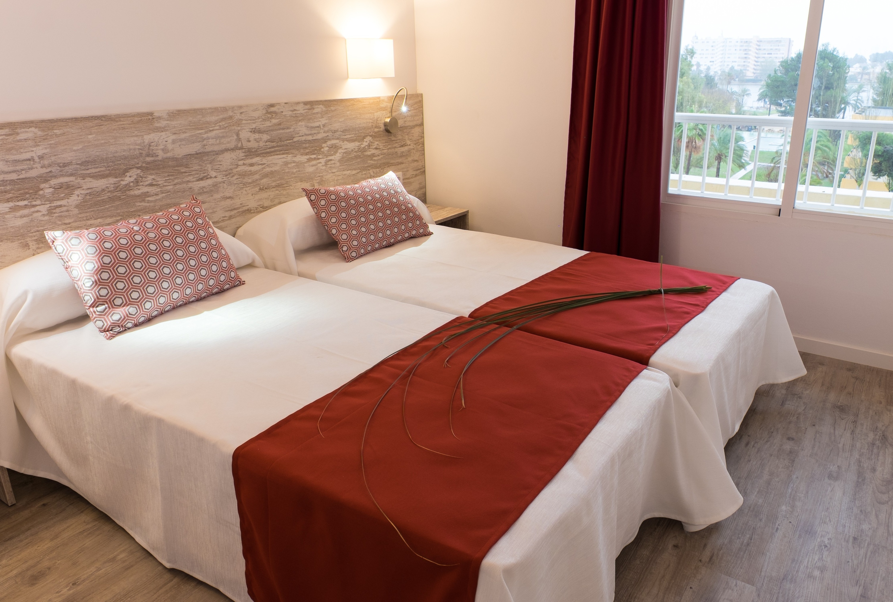Twin beds with red runner and decorative pillows. Beklub | O7 Hotels | Mallorca | Official website.