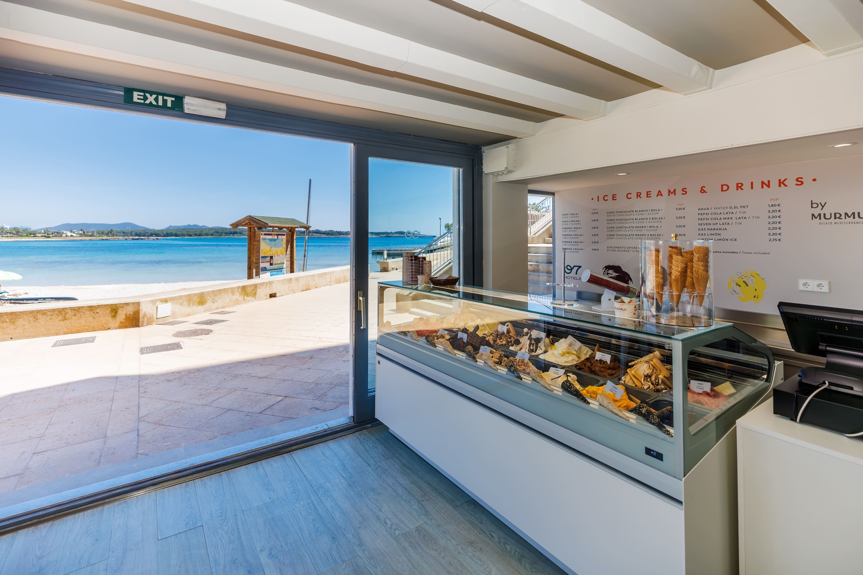 una tienda de helados y bebidas con una puerta que da a la playa