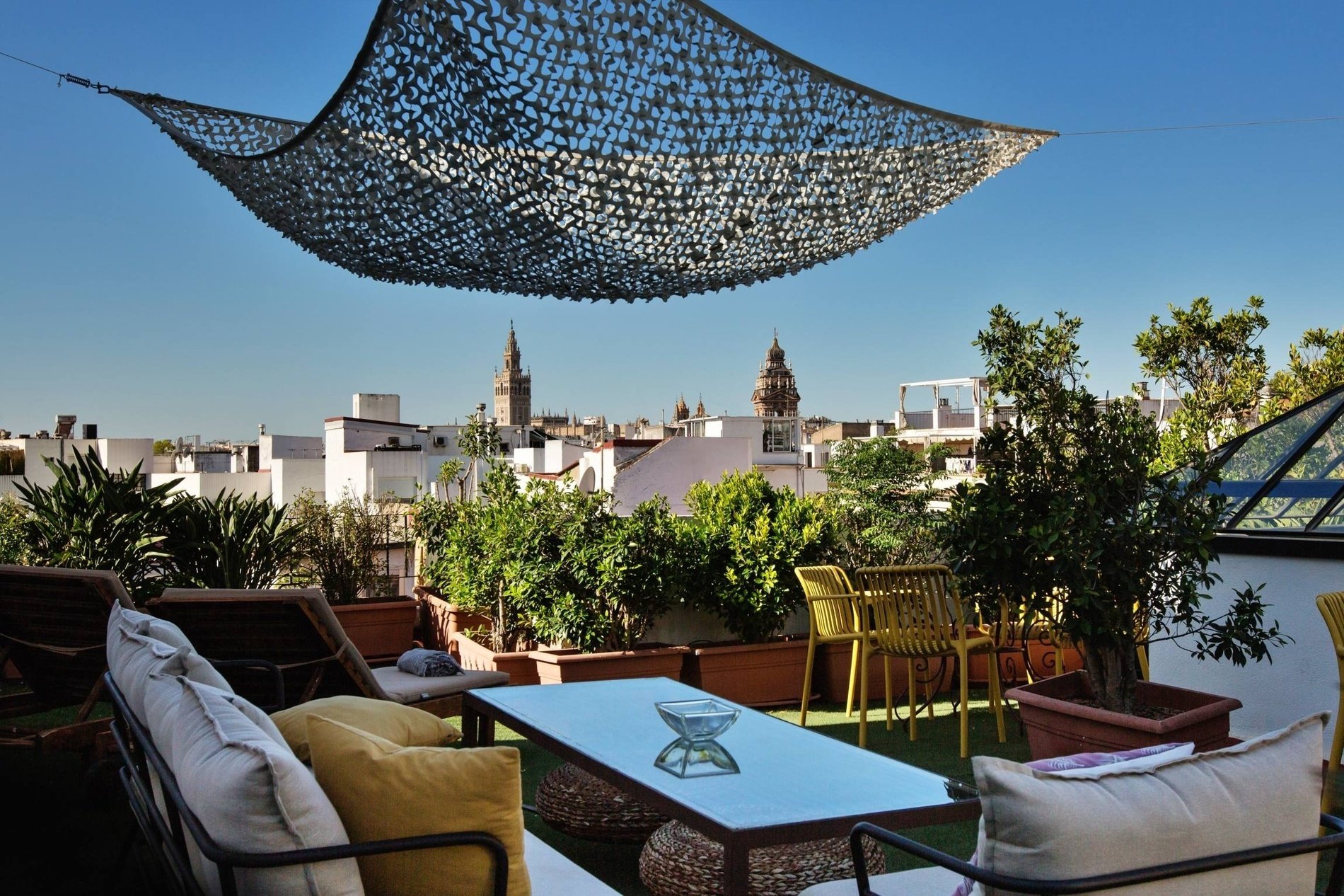 una hamaca cuelga del techo de una terraza con muebles y plantas