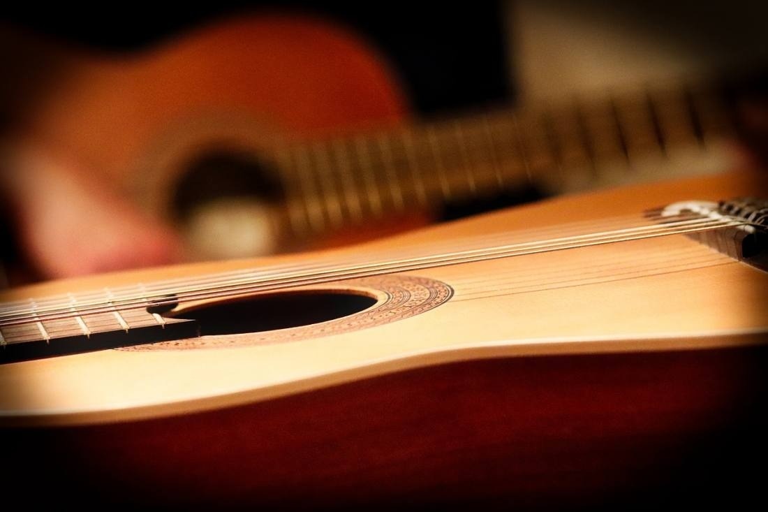 a close up of an acoustic guitar with a blurred background