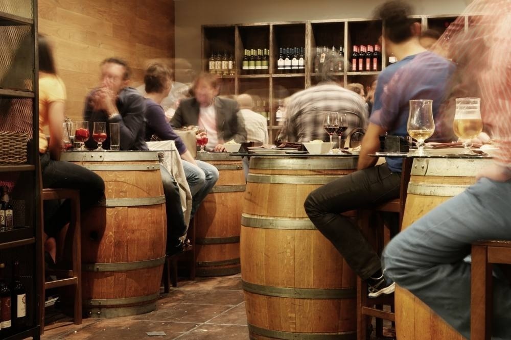 people sitting at wooden barrels in a restaurant