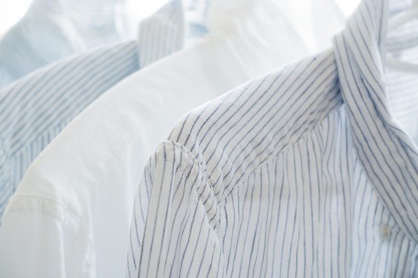 a stack of blue and white striped shirts with white buttons